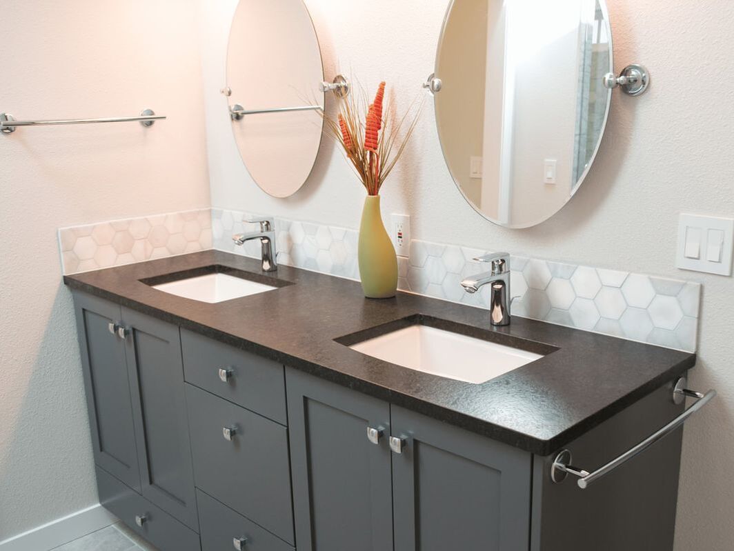 Dark gray two sink vanity with multiple drawers and cabinets