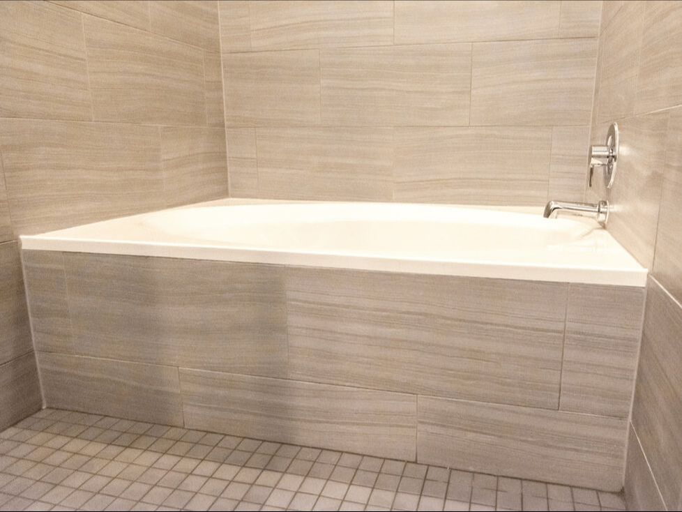 Round bathtub with tile siding inside a bathroom