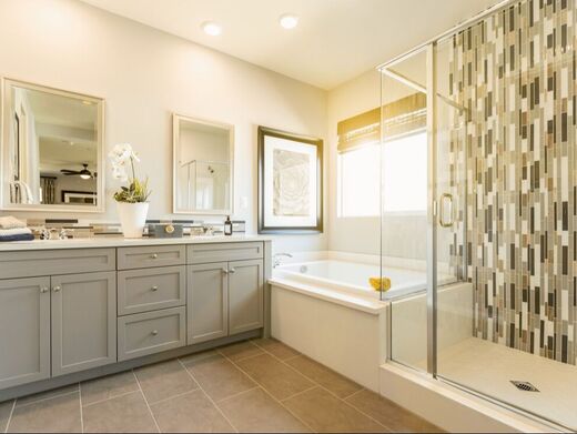 Bathroom with gray and white vanity, joint bathtub and shower, with overlapping tile floor